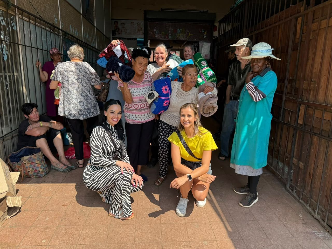Aletia and Candice handing out blankets to people in need